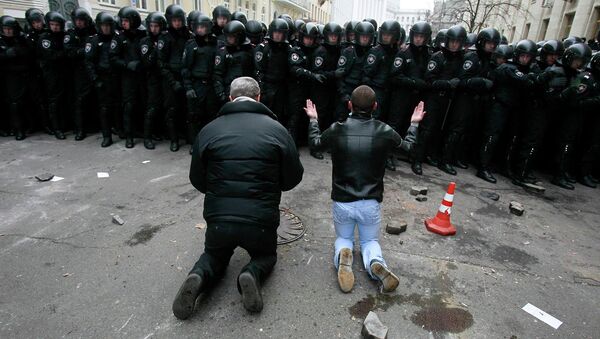 Люди стоят на коленях перед милицией во время митинга сторонников евроинтеграции в Киеве Люди стоят на коленях перед милицией во время митинга сторонников евроинтеграции в Киеве