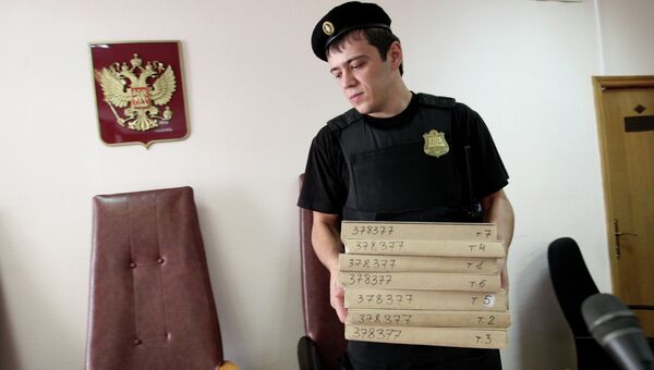 Судебный пристав держит в руках папки с документами, архивное фото Судебный пристав держит в руках папки с документами, архивное фото